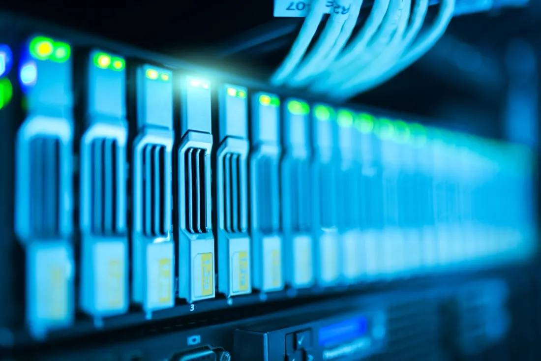 A close-up of illuminated server storage modules and cabling in a data centre, reflecting risks around new technology adoption