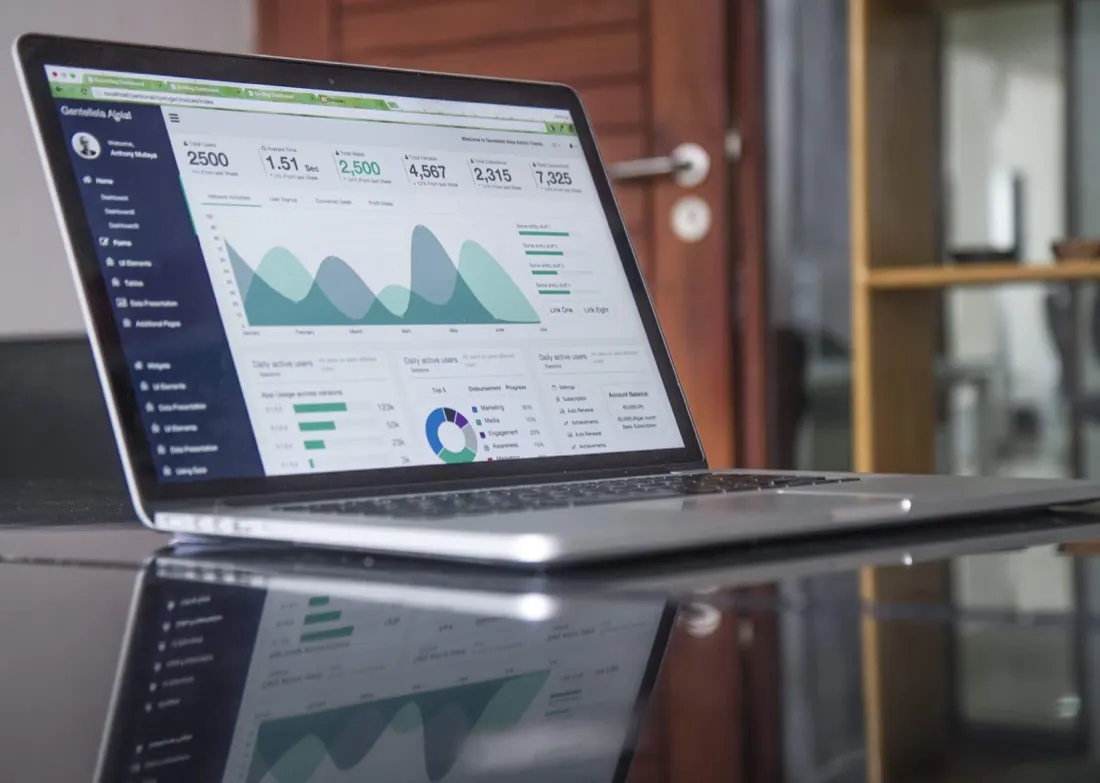 Laptop on a desk showing an analytics dashboard with charts, illustrating rising analytics spending