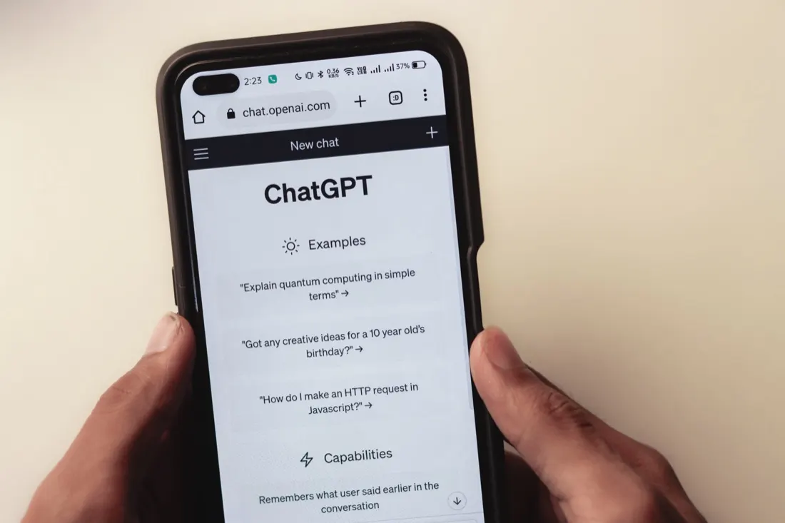 Hands holding a smartphone open to the ChatGPT app, reflecting AI's role in tech recruitment