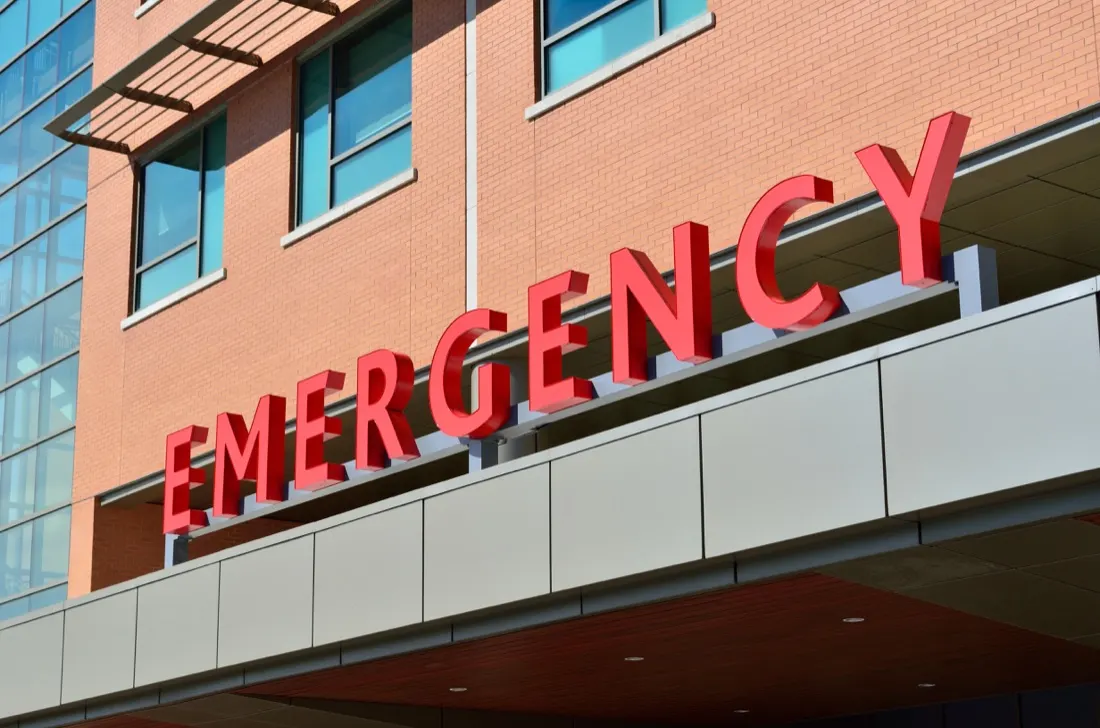 Red Emergency sign mounted on a hospital building entrance, illustrating cultural change in healthcare during a crisis