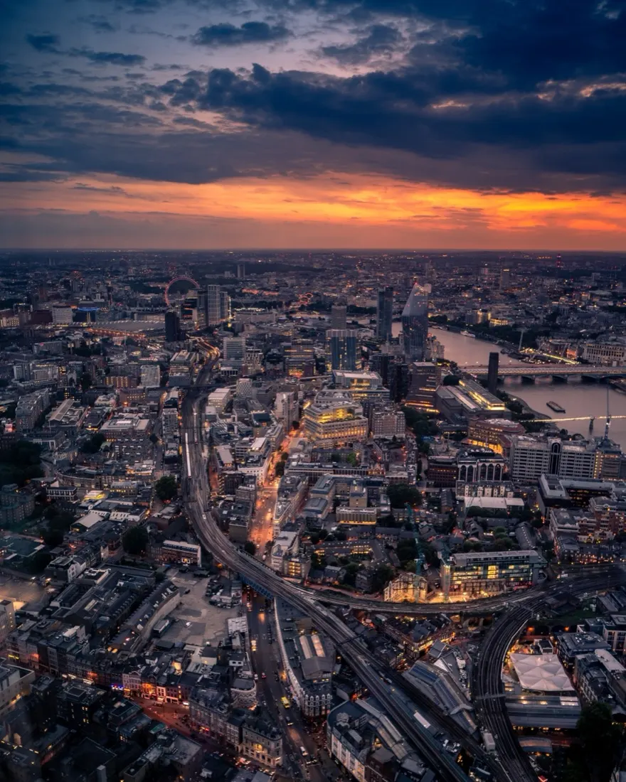 Aerial view of a city skyline at sunset with a river running through it, illustrating the UK economy and intellectual property rights