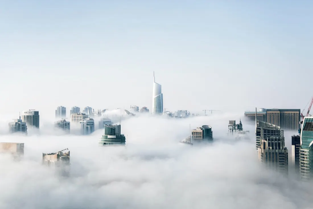 A city skyline of office towers emerging above the clouds, illustrating composable ERP strategy and cloud migration